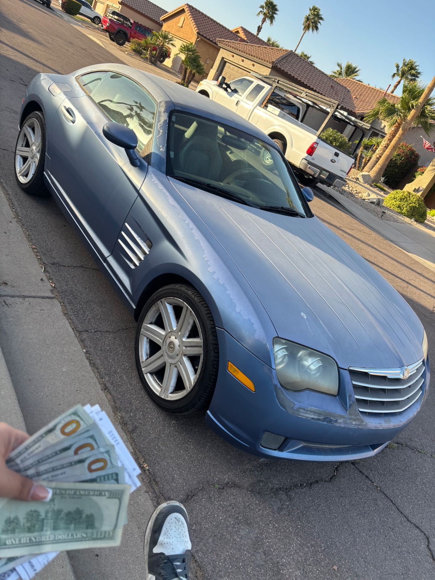Cash being handed over for a Chrysler Crossfire in a Las Vegas neighborhood driveway